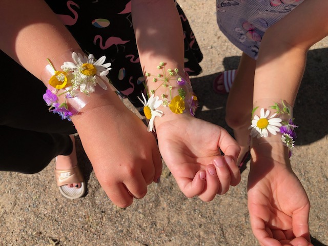 lasten kädet, joissa kukista tehdyt käsikorut